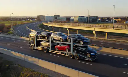 Car transporter with the Milton Keynes, Buckinghamshire, United Kingdom skyline behind it