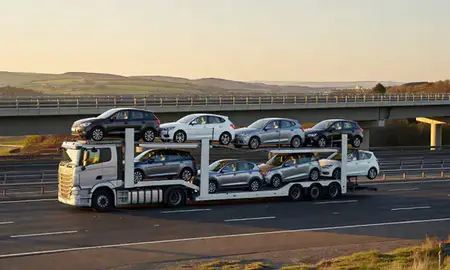 Car transporter with the County Antrim, United Kingdom skyline behind it