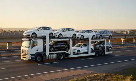 Car transporter with the County Durham, United Kingdom skyline behind it