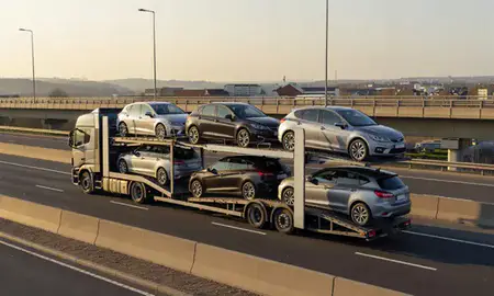Car transporter with the Long Eaton, Derbyshire, United Kingdom skyline behind it