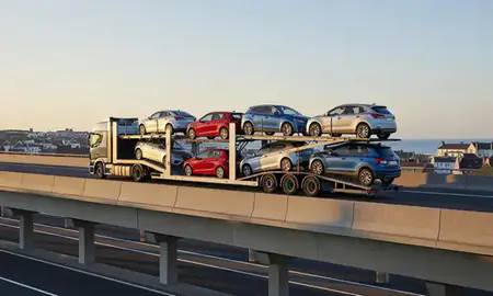 Car transporter with the Exmouth, Devon, United Kingdom skyline behind it