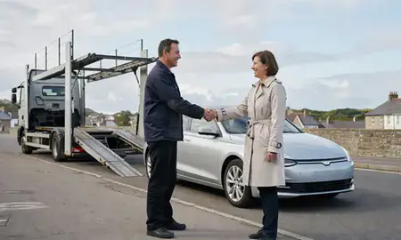 Vehicle owner beside their delivered car in Paignton, Devon, United Kingdom
