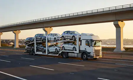 Car transporter with the Weymouth, Dorset, United Kingdom skyline behind it