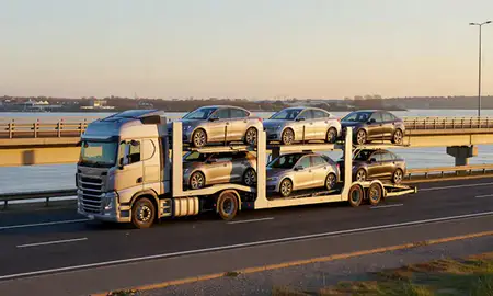 Car transporter with the Canvey Island, Essex, United Kingdom skyline behind it