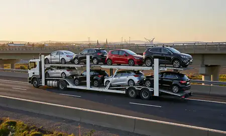 Car transporter with the Falkirk, United Kingdom skyline behind it
