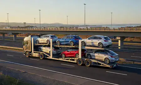 Car transporter with the Kirkcaldy, Fife, United Kingdom skyline behind it