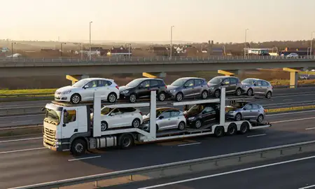 Car transporter with the Andover, Hampshire, United Kingdom skyline behind it