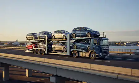 Car transporter with the Gosport, Hampshire, United Kingdom skyline behind it