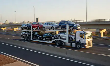 Car transporter with the Southampton, Hampshire, United Kingdom skyline behind it