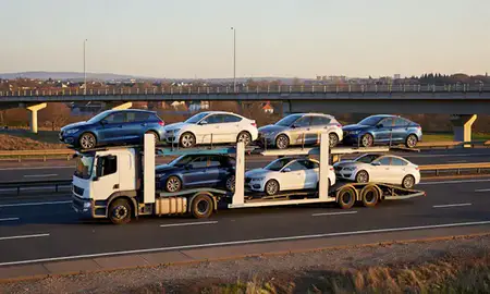 Car transporter with the Borehamwood, Hertfordshire, United Kingdom skyline behind it