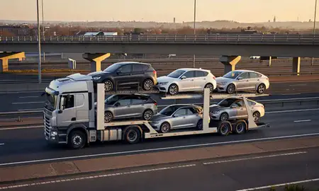 Car transporter with the Hoddesdon, Hertfordshire, United Kingdom skyline behind it