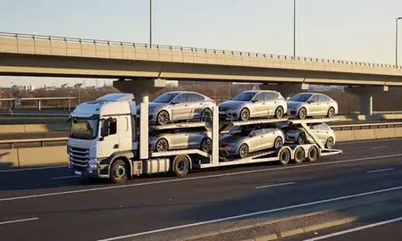 Car transporter with the Watford, Hertfordshire, United Kingdom skyline behind it