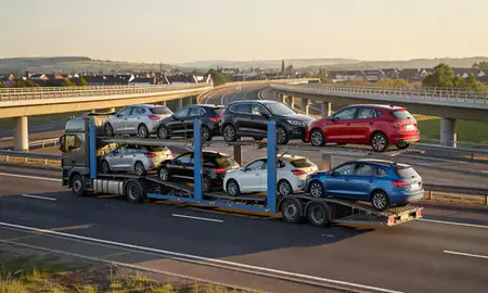 Car transporter with the Royal Tunbridge Wells, Kent, United Kingdom skyline behind it