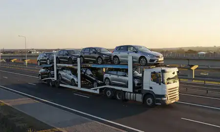 Car transporter with the Tonbridge, Kent, United Kingdom skyline behind it