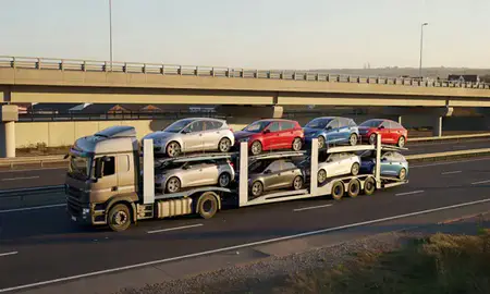 Car transporter with the Bamber Bridge, Lancashire, United Kingdom skyline behind it
