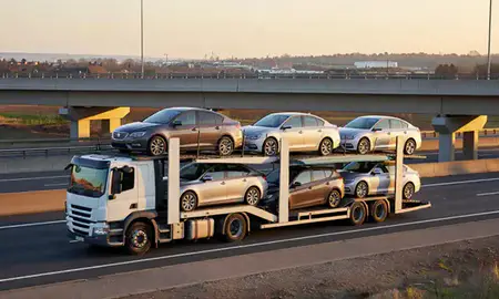Car transporter with the Loughborough, Leicestershire, United Kingdom skyline behind it