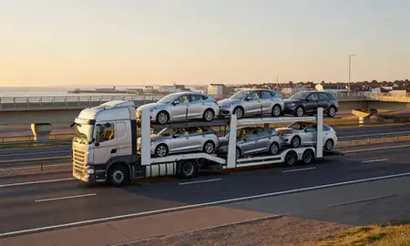 Car transporter with the Cleethorpes, Lincolnshire, United Kingdom skyline behind it