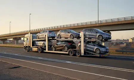 Car transporter with the Grimsby, Lincolnshire, United Kingdom skyline behind it