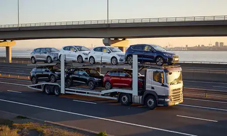 Car transporter with the Merseyside, United Kingdom skyline behind it
