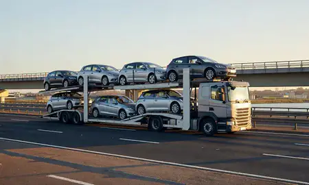 Car transporter with the Bebington, Merseyside, United Kingdom skyline behind it