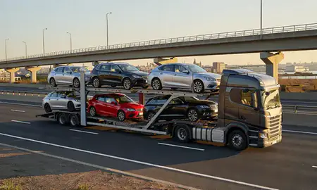 Car transporter with the Birkenhead, Merseyside, United Kingdom skyline behind it
