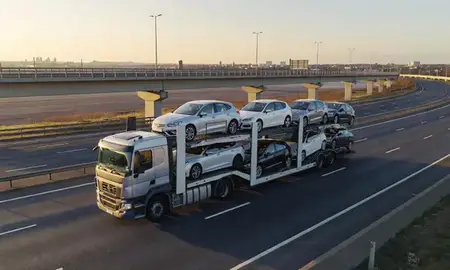 Car transporter with the Kirkby, Merseyside, United Kingdom skyline behind it
