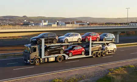 Car transporter with the Mid Glamorgan, United Kingdom skyline behind it