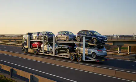 Car transporter with the Bridgend, Mid Glamorgan, United Kingdom skyline behind it