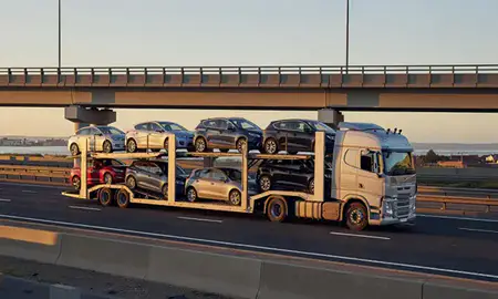 Car transporter with the Redcar, North Yorkshire, United Kingdom skyline behind it