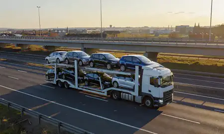 Car transporter with the Northampton, Northamptonshire, United Kingdom skyline behind it