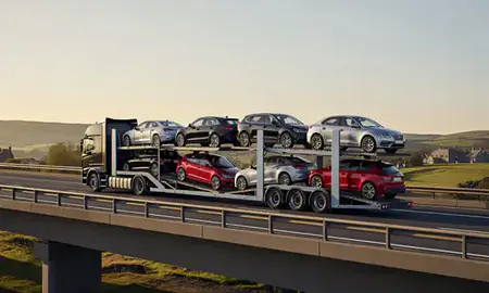 Car transporter with the Northumberland, United Kingdom skyline behind it