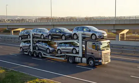 Car transporter with the Beeston, Nottinghamshire, United Kingdom skyline behind it