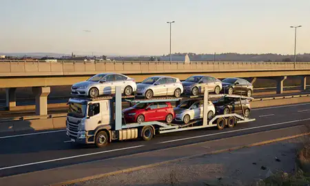 Car transporter with the Banbury, Oxfordshire, United Kingdom skyline behind it