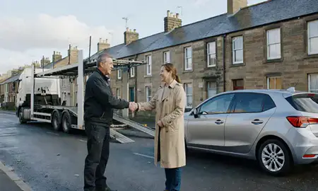 Vehicle owner beside their delivered car in Paisley, Renfrewshire, United Kingdom