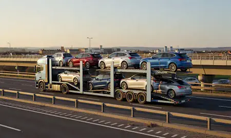 Car transporter with the Bridgwater, Somerset, United Kingdom skyline behind it