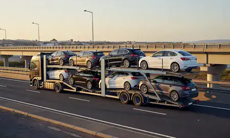 Car transporter with the Barry, South Glamorgan, United Kingdom skyline behind it