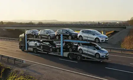 Car transporter with the Staffordshire, United Kingdom skyline behind it