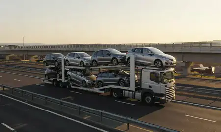 Car transporter with the Cannock, Staffordshire, United Kingdom skyline behind it
