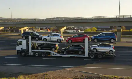 Car transporter with the Tamworth, Staffordshire, United Kingdom skyline behind it
