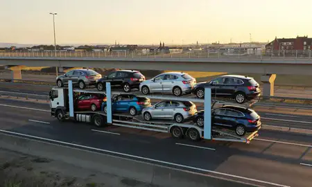 Car transporter with the Lowestoft, Suffolk, United Kingdom skyline behind it