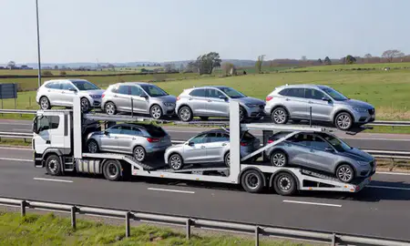 Multi-level car carrier on the motorway to Walton-on-Thames, Surrey, United Kingdom