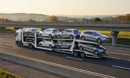 Car transporter with the Warwickshire, United Kingdom skyline behind it