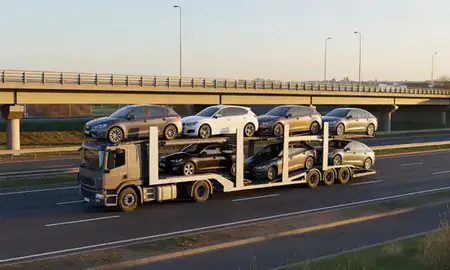 Car transporter with the Rugby, Warwickshire, United Kingdom skyline behind it