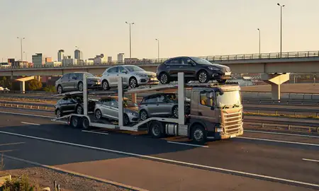 Car transporter with the Birmingham, West Midlands, United Kingdom skyline behind it