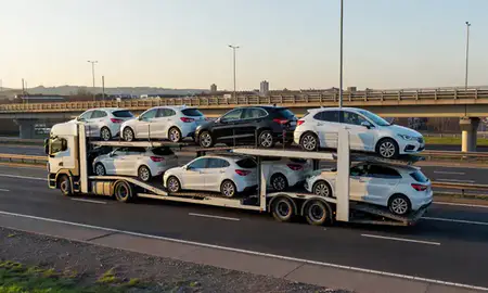 Car transporter with the Wolverhampton, West Midlands, United Kingdom skyline behind it