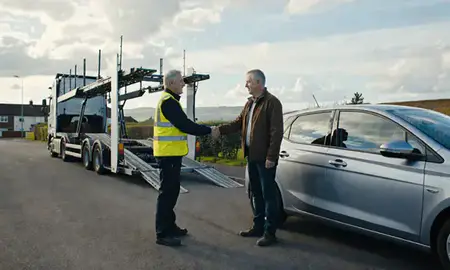 Vehicle owner beside their delivered car in Keighley, West Yorkshire, United Kingdom