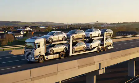 Car transporter with the Trowbridge, Wiltshire, United Kingdom skyline behind it