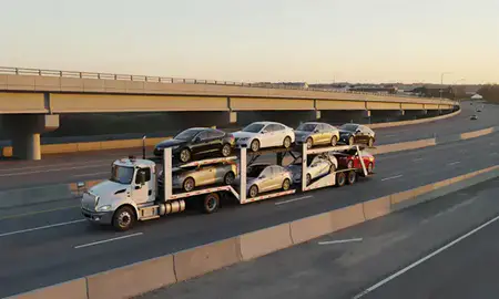 Car transporter with the Albertville, Alabama, United States skyline behind it