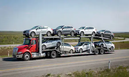 Multi-level car carrier on the highway to Bethel, Alaska, United States