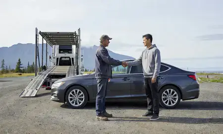 Vehicle owner beside their delivered car in Homer, Alaska, United States